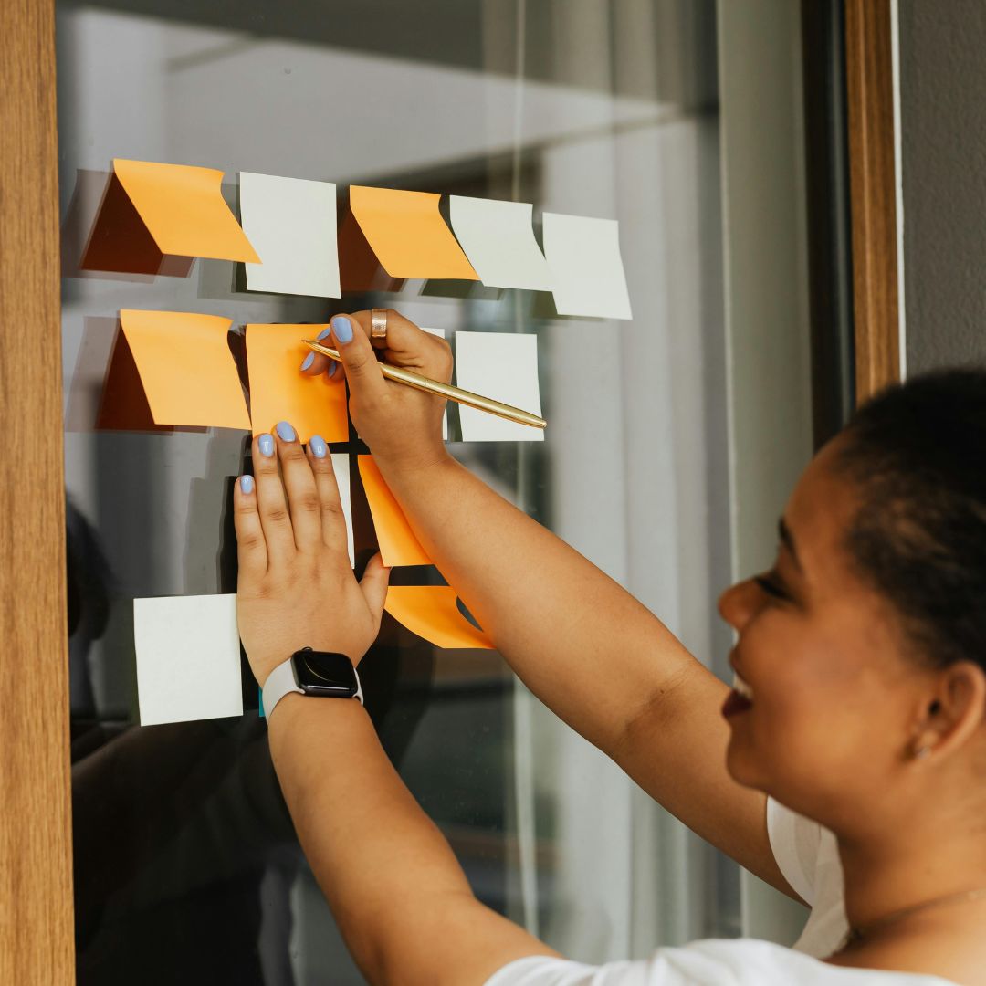 woman writing on sticky notes